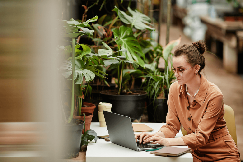 woman banking online near potted plants